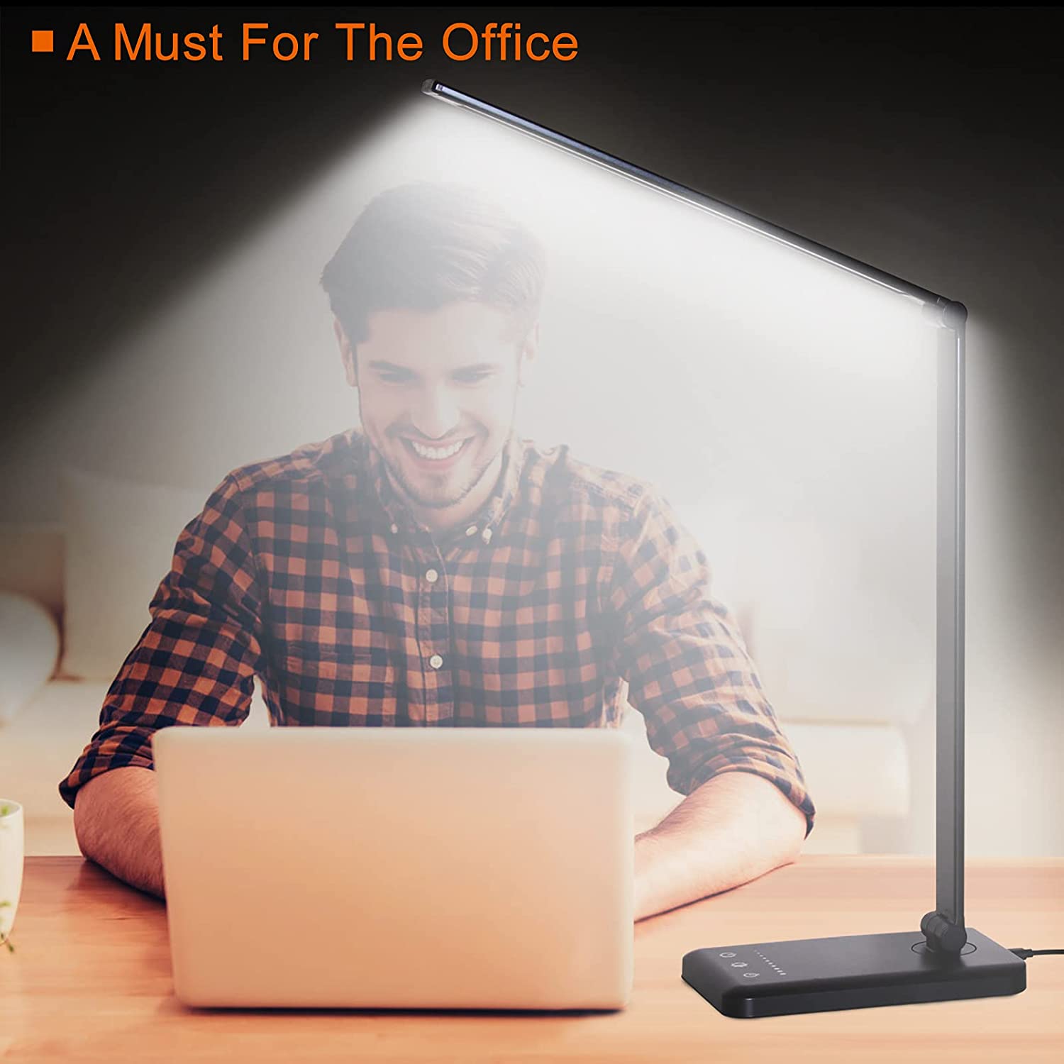 Modern LED desk lamp with wireless phone charger illuminating a minimalist office desk
