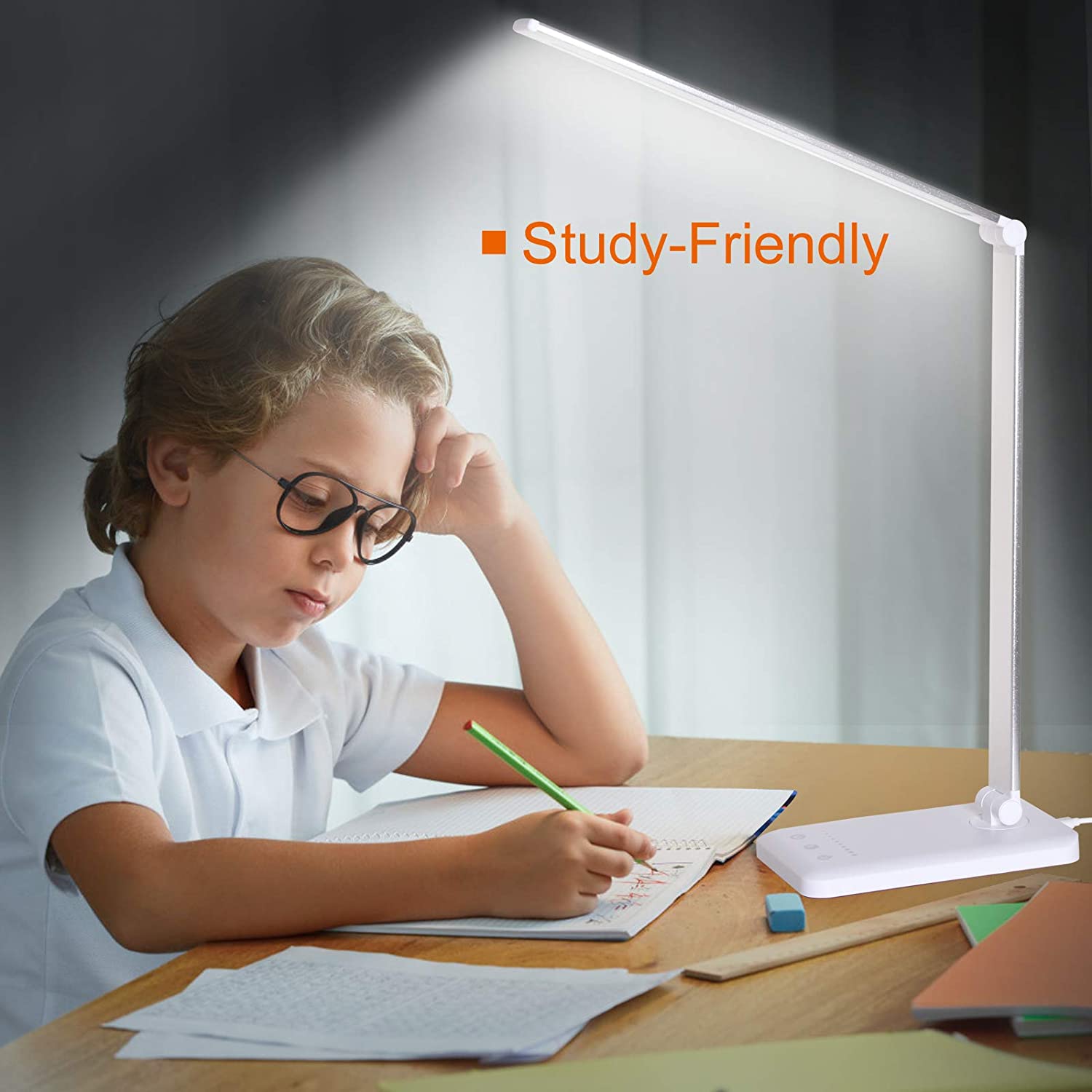 Modern LED desk lamp with wireless phone charger illuminating a minimalist office desk