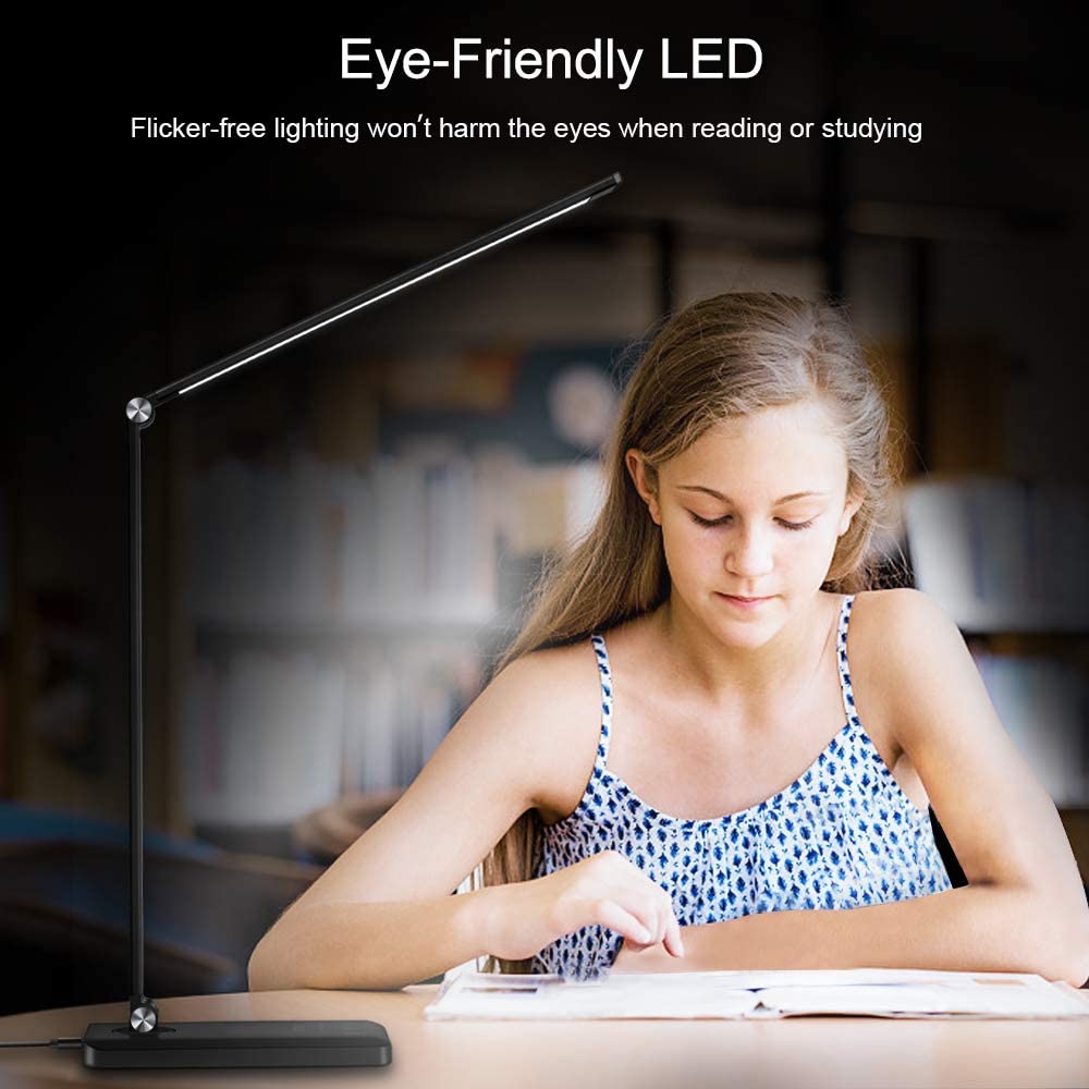 Modern LED desk lamp with wireless phone charger illuminating a minimalist office desk