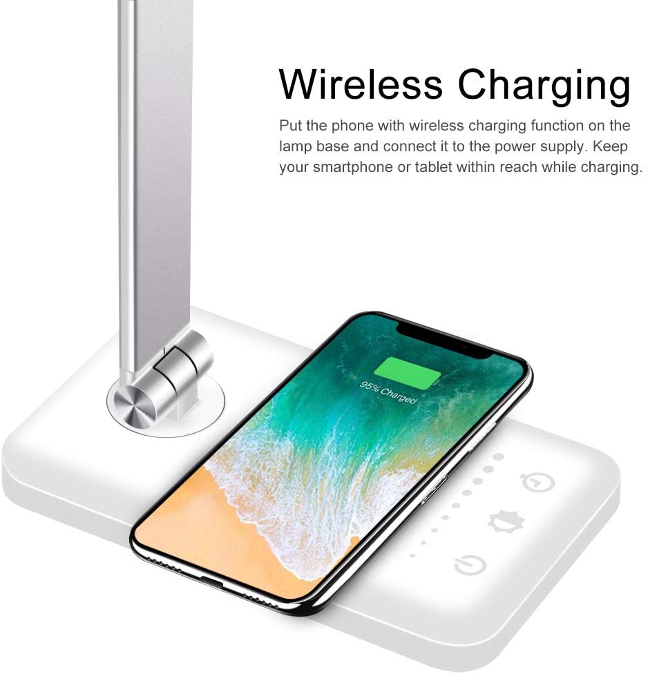 Modern LED desk lamp with wireless phone charger illuminating a minimalist office desk