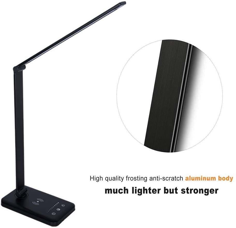 Modern LED desk lamp with wireless phone charger illuminating a minimalist office desk