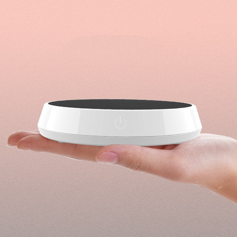 Smart coffee mug warmer keeping a ceramic coffee cup at the perfect drinking temperature on an office desk