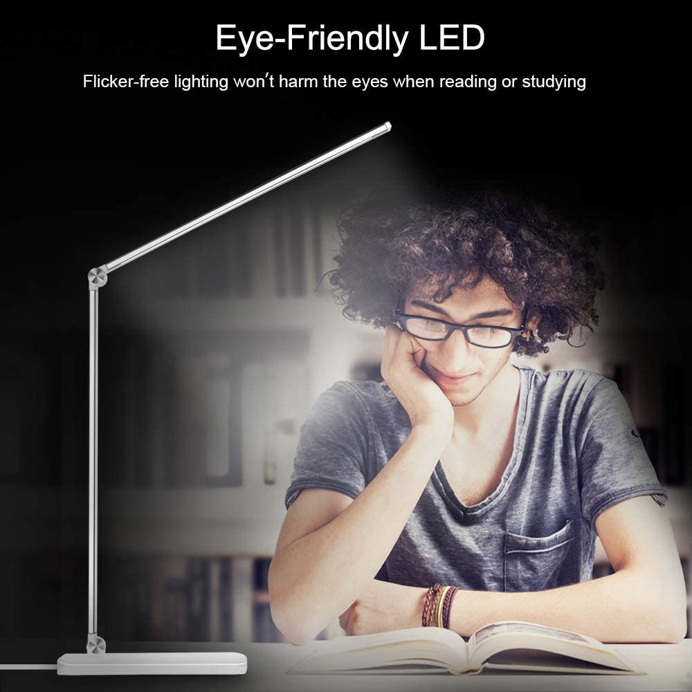 Modern LED desk lamp with wireless phone charger illuminating a minimalist office desk