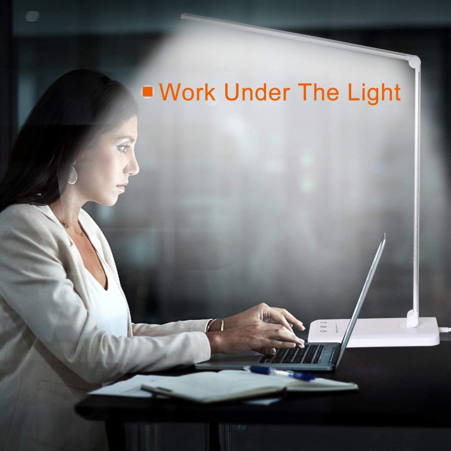 Modern LED desk lamp with wireless phone charger illuminating a minimalist office desk