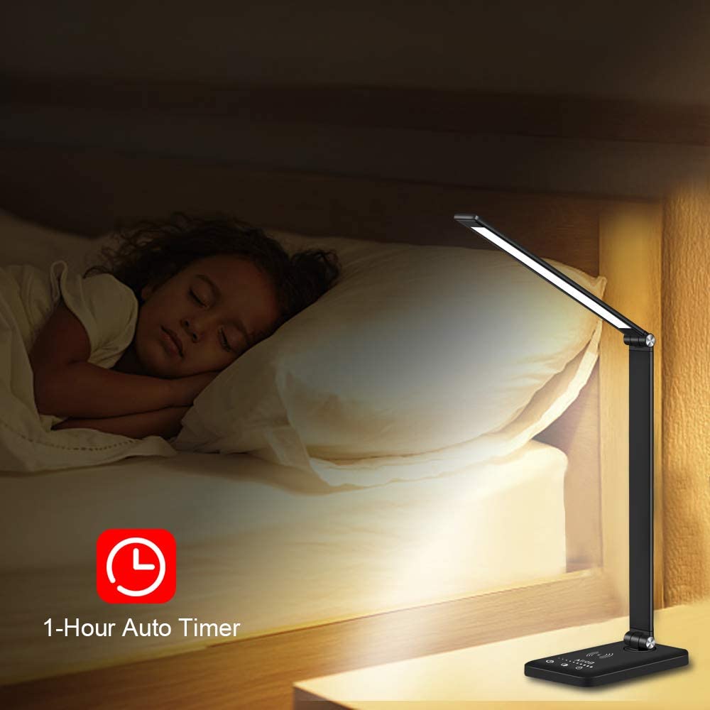 Modern LED desk lamp with wireless phone charger illuminating a minimalist office desk