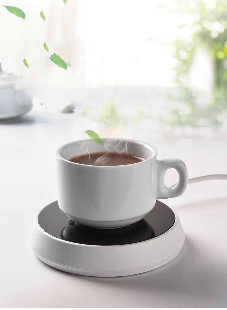 Smart coffee mug warmer keeping a ceramic coffee cup at the perfect drinking temperature on an office desk
